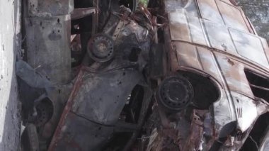 This stock vertical video shows a dump of shot and burned cars in Irpin, Bucha district , grey, flat video