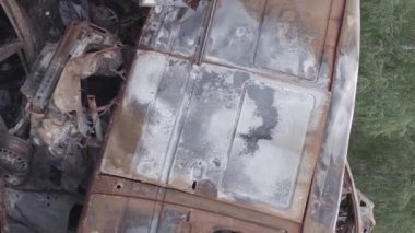 This stock vertical video shows a dump of shot and burned cars in Irpin, Bucha district , grey, flat video