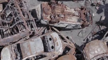 This stock vertical video shows a dump of shot and burned cars in Irpin, Bucha district , grey, flat video