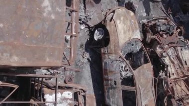 This stock vertical video shows a dump of shot and burned cars in Irpin, Bucha district , grey, flat video