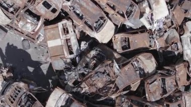 This stock vertical video shows a dump of shot and burned cars in Irpin, Bucha district , grey, flat video