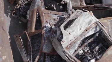 This stock vertical video shows a dump of shot and burned cars in Irpin, Bucha district , grey, flat video