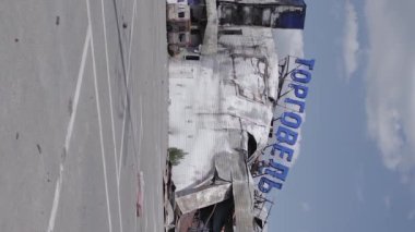 This stock vertical video shows a destroyed building of a shopping center in Bucha during the war in Ukraine, grey, flat video