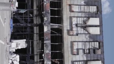 This stock vertical video shows a destroyed building of a shopping center in Bucha during the war in Ukraine, grey, flat video