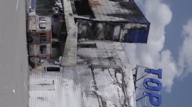 This stock vertical video shows a destroyed building of a shopping center in Bucha during the war in Ukraine, grey, flat video