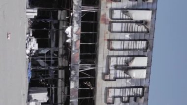 This stock vertical video shows a destroyed building of a shopping center in Bucha during the war in Ukraine, grey, flat video