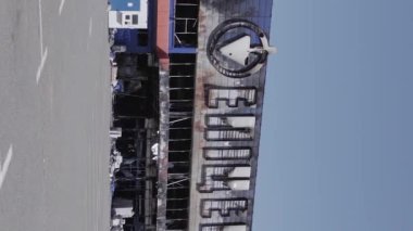 This stock vertical video shows a destroyed building of a shopping center in Bucha during the war in Ukraine, grey, flat video