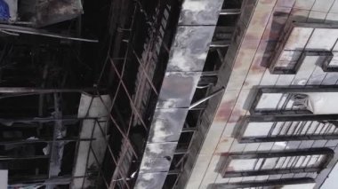 This stock vertical video shows a destroyed building of a shopping center in Bucha during the war in Ukraine, grey, flat video