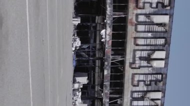 This stock vertical video shows a destroyed building of a shopping center in Bucha during the war in Ukraine, grey, flat video