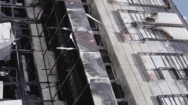 This stock vertical video shows a destroyed building of a shopping center in Bucha during the war in Ukraine, grey, flat video