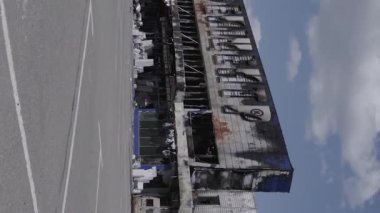This stock vertical video shows a destroyed building of a shopping center in Bucha during the war in Ukraine, grey, flat video