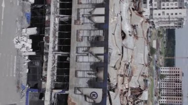 This stock vertical video shows a destroyed building of a shopping center in Bucha during the war in Ukraine, grey, flat video