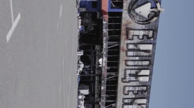 This stock vertical video shows a destroyed building of a shopping center in Bucha during the war in Ukraine, grey, flat video