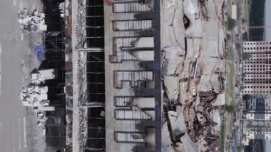 This stock vertical video shows a destroyed building of a shopping center in Bucha during the war in Ukraine, grey, flat video