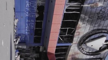 This stock vertical video shows a destroyed building of a shopping center in Bucha during the war in Ukraine, grey, flat video