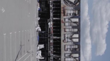 This stock vertical video shows a destroyed building of a shopping center in Bucha during the war in Ukraine, grey, flat video