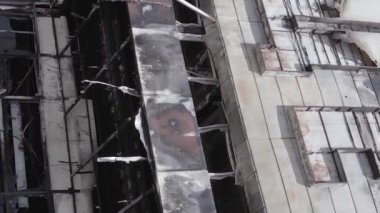 This stock vertical video shows a destroyed building of a shopping center in Bucha during the war in Ukraine, grey, flat video