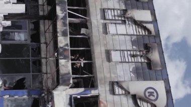 This stock vertical video shows a destroyed building of a shopping center in Bucha during the war in Ukraine, grey, flat video