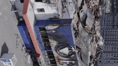 This stock vertical video shows a destroyed building of a shopping center in Bucha during the war in Ukraine, grey, flat video