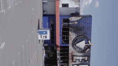 This stock vertical video shows a destroyed building of a shopping center in Bucha during the war in Ukraine, grey, flat video