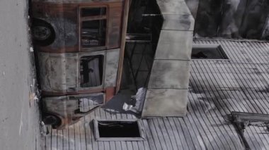 This stock vertical video shows a destroyed building of a shopping center in Bucha during the war in Ukraine, grey, flat video