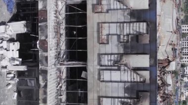 This stock vertical video shows a destroyed building of a shopping center in Bucha during the war in Ukraine, grey, flat video