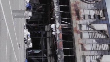 This stock vertical video shows a destroyed building of a shopping center in Bucha during the war in Ukraine, grey, flat video