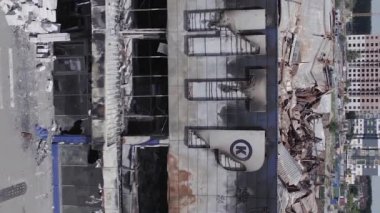 This stock vertical video shows a destroyed building of a shopping center in Bucha during the war in Ukraine, grey, flat video