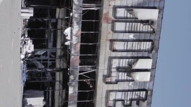 This stock vertical video shows a destroyed building of a shopping center in Bucha during the war in Ukraine, grey, flat video