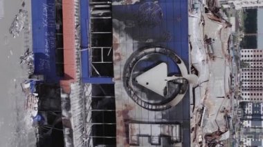 This stock vertical video shows a destroyed building of a shopping center in Bucha during the war in Ukraine, grey, flat video