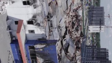 This stock vertical video shows a destroyed building of a shopping center in Bucha during the war in Ukraine, grey, flat video