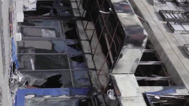 This stock vertical video shows a destroyed building of a shopping center in Bucha during the war in Ukraine, grey, flat video