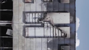 This stock vertical video shows a destroyed building of a shopping center in Bucha during the war in Ukraine, grey, flat video