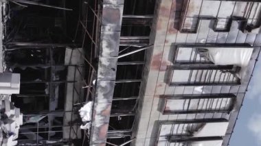 This stock vertical video shows a destroyed building of a shopping center in Bucha during the war in Ukraine, grey, flat video