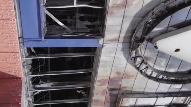 This stock vertical video shows a destroyed building of a shopping center in Bucha during the war in Ukraine, grey, flat video
