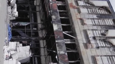 This stock vertical video shows a destroyed building of a shopping center in Bucha during the war in Ukraine, grey, flat video