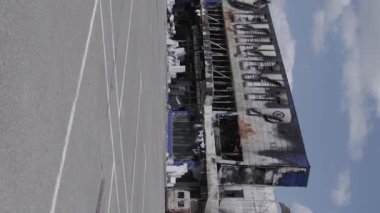 This stock vertical video shows a destroyed building of a shopping center in Bucha during the war in Ukraine, grey, flat video