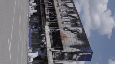 This stock vertical video shows a destroyed building of a shopping center in Bucha during the war in Ukraine, grey, flat video