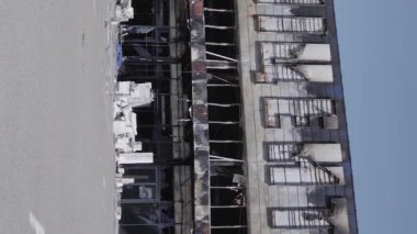 This stock vertical video shows a destroyed building of a shopping center in Bucha during the war in Ukraine, grey, flat video