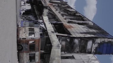 This stock vertical video shows a destroyed building of a shopping center in Bucha during the war in Ukraine, grey, flat video