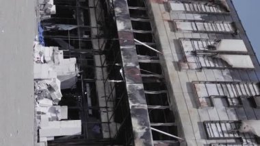This stock vertical video shows a destroyed building of a shopping center in Bucha during the war in Ukraine, grey, flat video