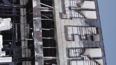 This stock vertical video shows a destroyed building of a shopping center in Bucha during the war in Ukraine, grey, flat video