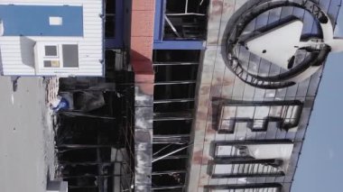 This stock vertical video shows a destroyed building of a shopping center in Bucha during the war in Ukraine, grey, flat video