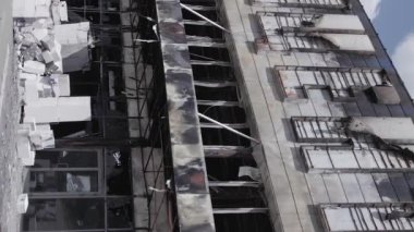 This stock vertical video shows a destroyed building of a shopping center in Bucha during the war in Ukraine, grey, flat video