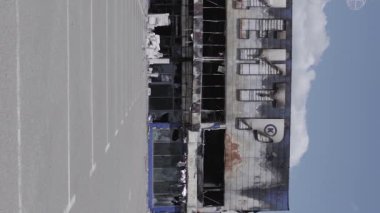 This stock vertical video shows a destroyed building of a shopping center in Bucha during the war in Ukraine, grey, flat video