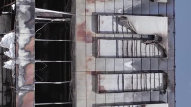This stock vertical video shows a destroyed building of a shopping center in Bucha during the war in Ukraine, grey, flat video