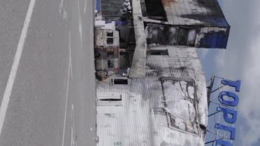 This stock vertical video shows a destroyed building of a shopping center in Bucha during the war in Ukraine, grey, flat video