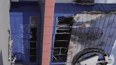 This stock vertical video shows a destroyed building of a shopping center in Bucha during the war in Ukraine, grey, flat video