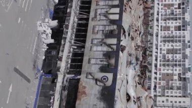 This stock vertical video shows a destroyed building of a shopping center in Bucha during the war in Ukraine, grey, flat video