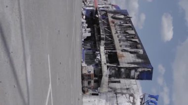 This stock vertical video shows a destroyed building of a shopping center in Bucha during the war in Ukraine, grey, flat video